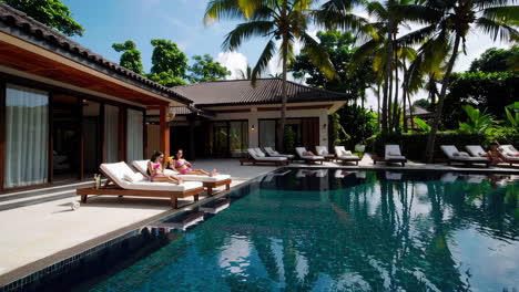 people relaxing by a luxurious private pool at a tropical resort