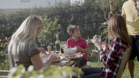 happy family with two children having dinner in garden