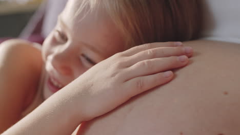 a little girl resting on her mother's lap.