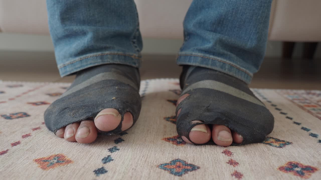 Person's Feet in Worn Out, Ripped Socks