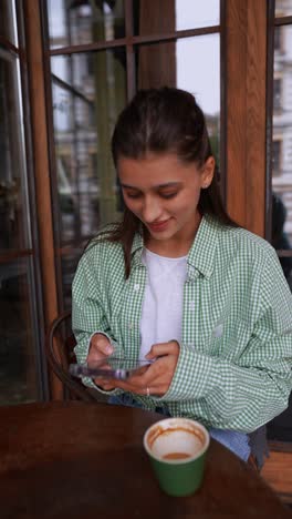 young woman using smartphone in a cafe