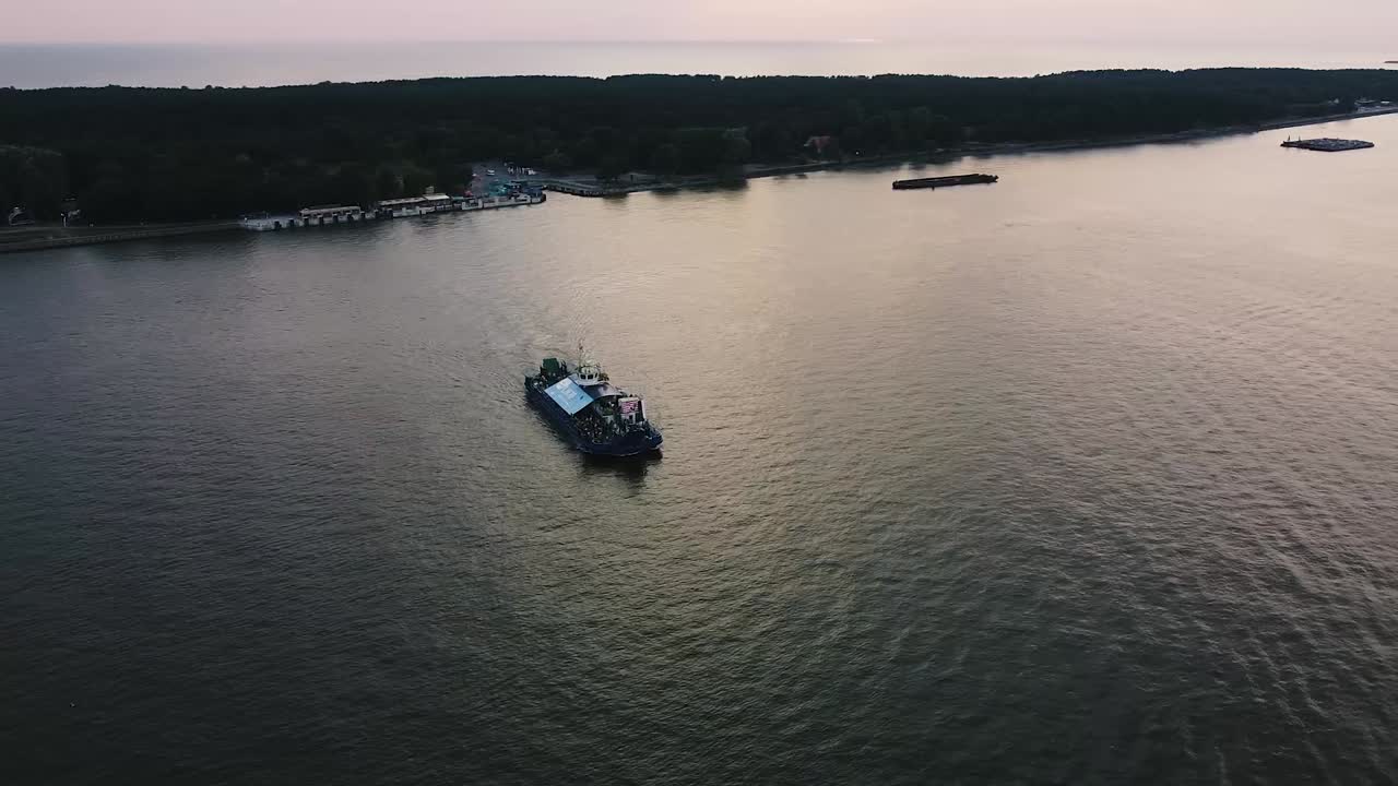 Ripresa aerea cinematografica con drone di un traghetto che attraversa il fiume con molte persone a bordo