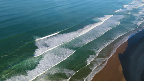 The-drone-continues-to-soar-higher,-revealing-the-vast-expanse-of-the-ocean-and-the-rugged-natural-coastline