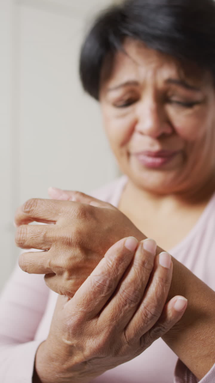 Video verticale di donna anziana birazziale che si tocca la mano