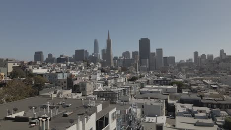 In-a-captivating-ascent,-a-drone-rises-above-the-vibrant-streets-of-San-Francisco,-showcasing-the-iconic-downtown-buildings,-providing-a-stunning-aerial-view-of-the-urban-landscape