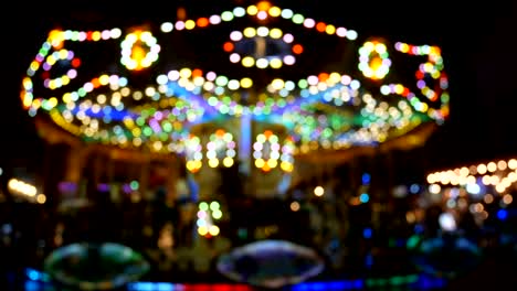 4k. abstract blur children's merry-go-round carousel at night with bokeh light on festival for background