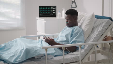 a black man is lying on a hospital bed and plowing a message to his friends and relatives from the hospital. communication with loved ones in the hospital via the internet and mobile devices