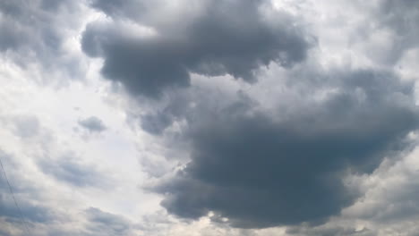 stormy grey clouds accumulating in the atmosphere. cumulus cloudscape formation in the sky from low angle view. timelapse.