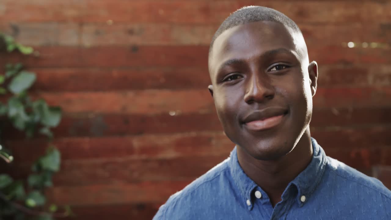 야외 테라스에서 웃는 행복한 아프리카계 미국인 남자의 초상화, 복사 공간, 느린 동작