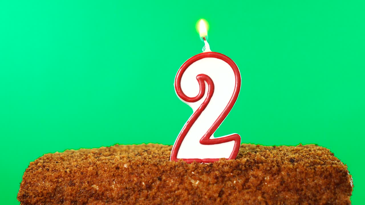 pastel con la vela encendida número 2. llave de croma. pantalla verde. aislado