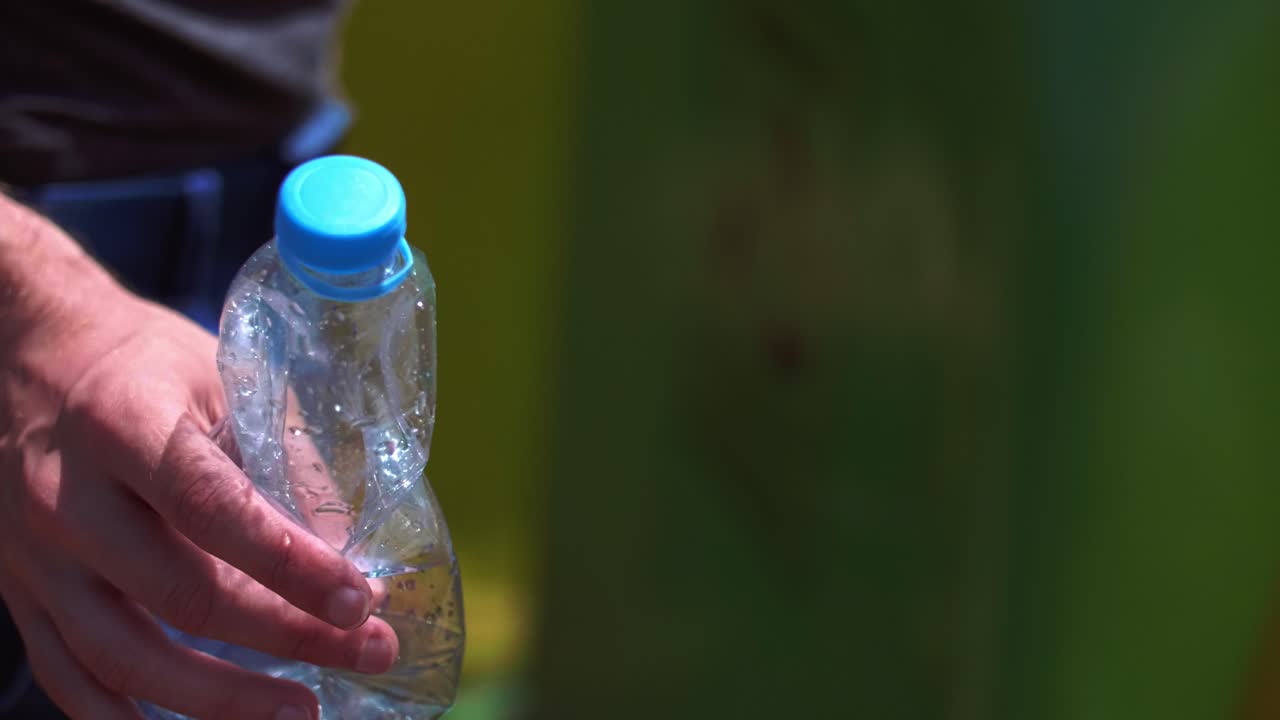 hombre tirando una botella de plástico vacía en el contenedor de reciclaje