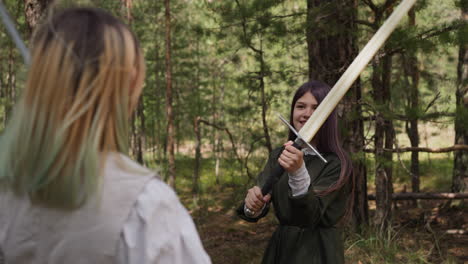 happy girl in medieval clothes fights on swords in forest