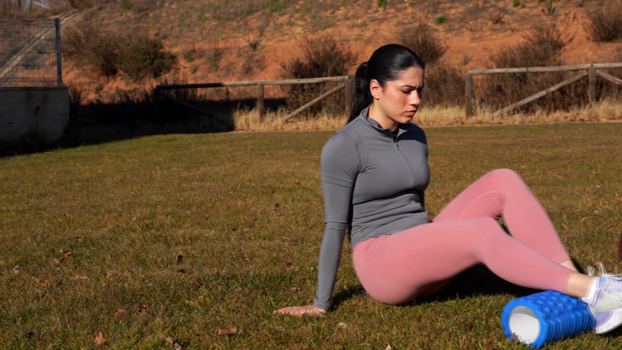 Young lady doing physiotherapy rehabilitation exercises in the park. Slowmo, pan right