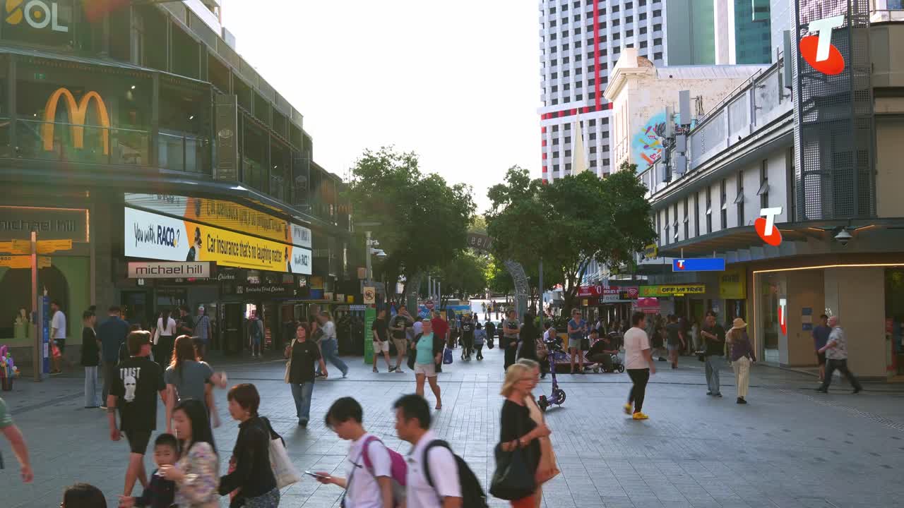 Busy urban street scene of downtown Brisbane city on the weekend, shoppers shopping at Queen street mall, people strolling at the outdoor pedestrian shopping precinct, time-lapse shot.