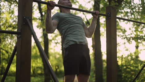 man doing pull-ups in the park