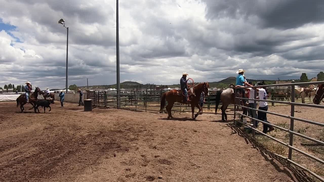 Cowboys ride into the corral.