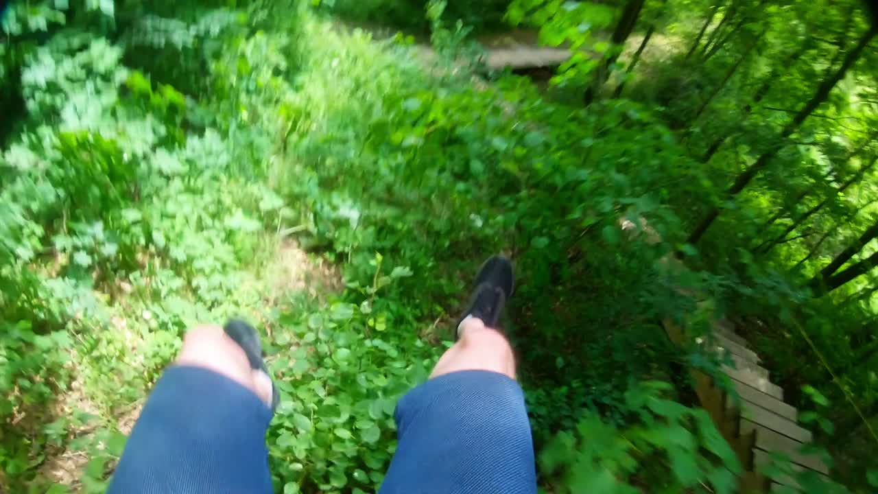 밧줄에 묶인 남자가 숲의 나뭇가지 위로 내려간다