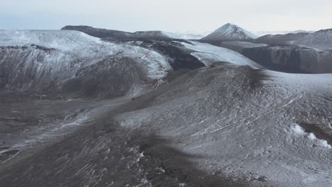 Iceland-wild-highland-mountains-with-light-snow-on-cloudy-day,-aerial