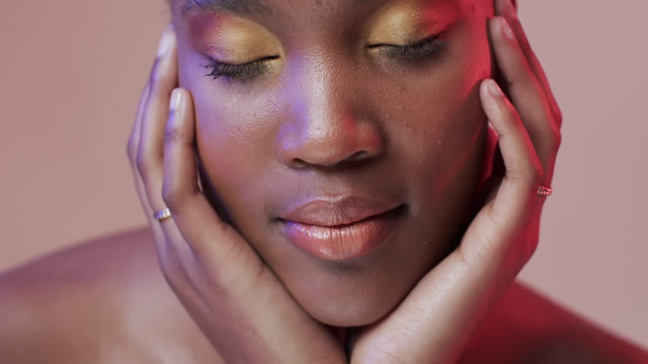 African american woman with short dark hair in blue and pink light, slow motion