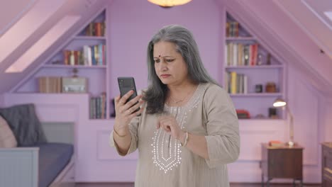 anciana india desplazándose por el teléfono