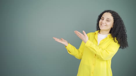 The-young-woman-promoting-is-pointing-to-the-side-and-laughing.