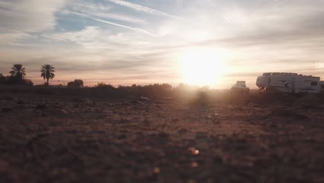 Low-angle-view-of-sunrise-over-a-graveled-campground---Arizona