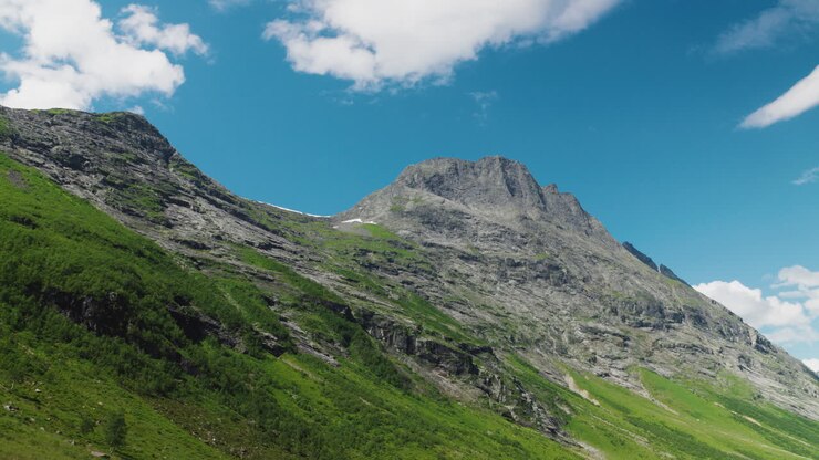 Weitwinkelaufnahme von majestätischen Bergen in Norwegen an einem hellen, sonnigen Tag mit einigen Wolken am Himmel