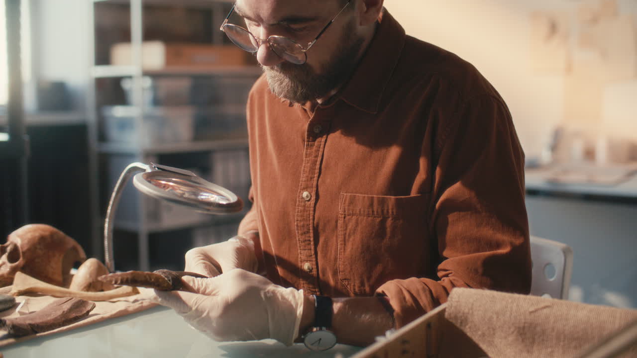 Ricercatore concentrato che studia un manufatto in laboratorio di archeologia