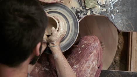 the potter makes a jug of clay. ceramist. a man makes a vase on a potter's wheel