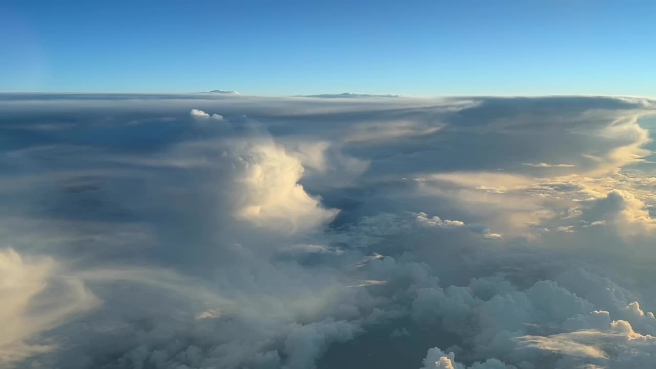 vista aérea desde una cabina de jet cerca de un enorme cumulonimbus al atardecer durante el nivel de crucero