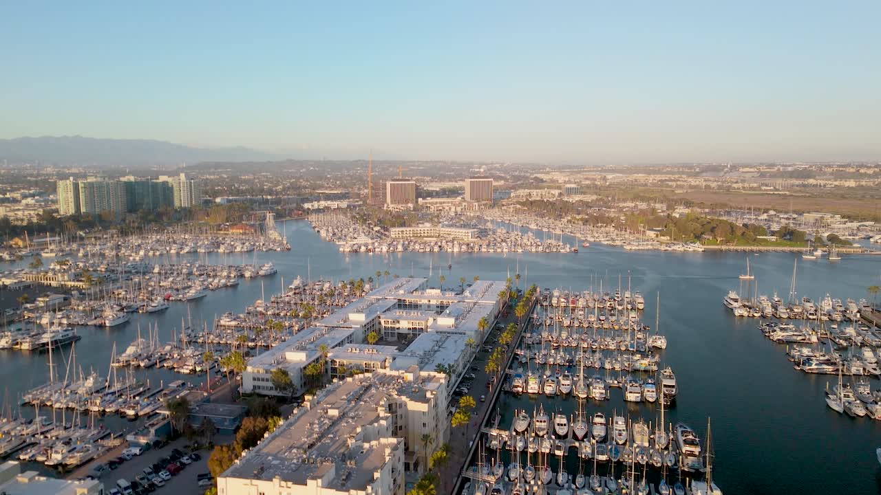 vista panorámica sobre marina del rey con barcos y yates atracados al atardecer en el condado de los ángeles, california - toma de dron
