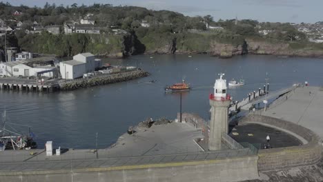 Coast-Guard-tows-fishing-boat-into-sunny-Dunmore-East-Harbour,-Ireland