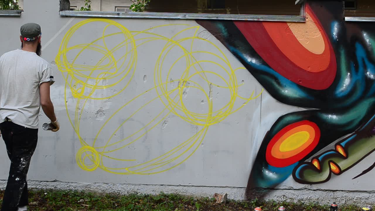 Prosessen med å lage graffiti, gjerde. Kunstneren tegner graffiti