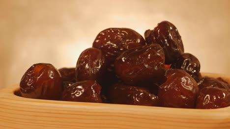 pitted turkish dates in a wooden plate rotate cyclically. slow rotation. eastern sweets. close-up. 4k