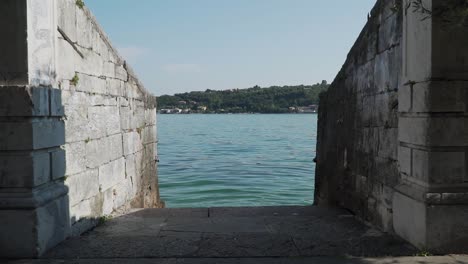 into the water in slow motion, stone brick walls, on the path to lake garda