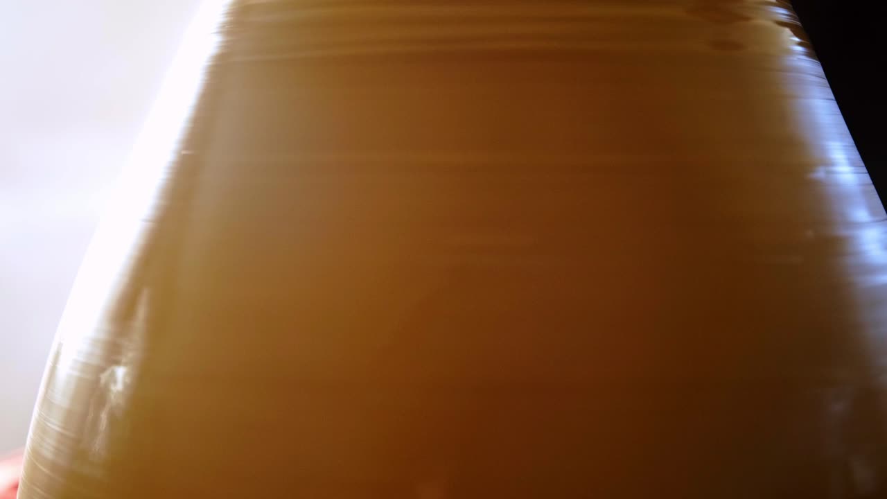 Exploring the Subtle Textures and Vivid Hues in a Captivating Close-up of a Lightly Colored Container, Showcasing Its Smooth Surfaces and Unique Reflection