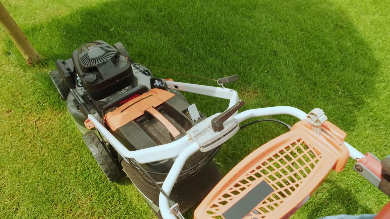 잔디를 는 잔디 기. 정원 활동. 빛 정원에서 가솔린 구동 잔디기와 함께 잔디을 는. 정원에서 잔디 자르기 기계와 함께 일하는 정원사. 잔디자리 기