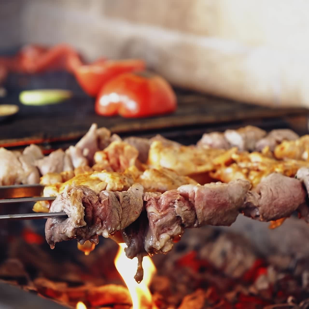 Barbeque on a stove. Meat and vegetables being grilled. Juicy meat and vegetables on coals. Kebab on metal skewers barbecue.