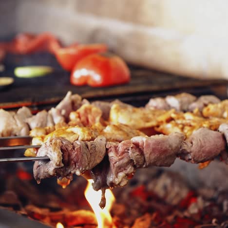 barbeque on a stove. meat and vegetables being grilled. juicy meat and vegetables on coals. kebab on metal skewers barbecue.