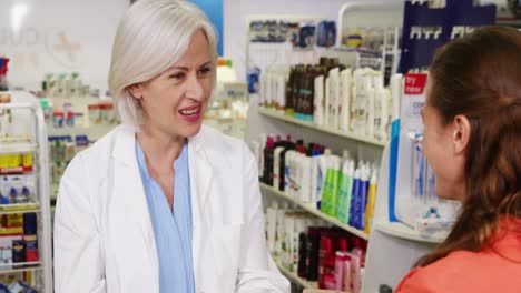 pharmacist packing medicine in paper bag for customer