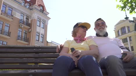 stylish senior couple relaxing on bench in the city