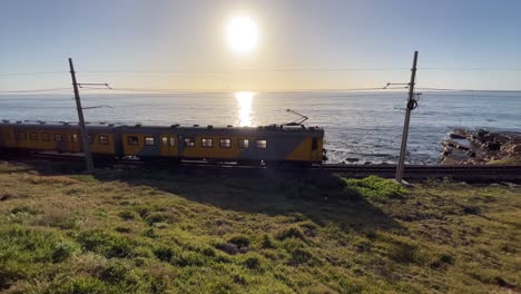 commuter train running along coastal track