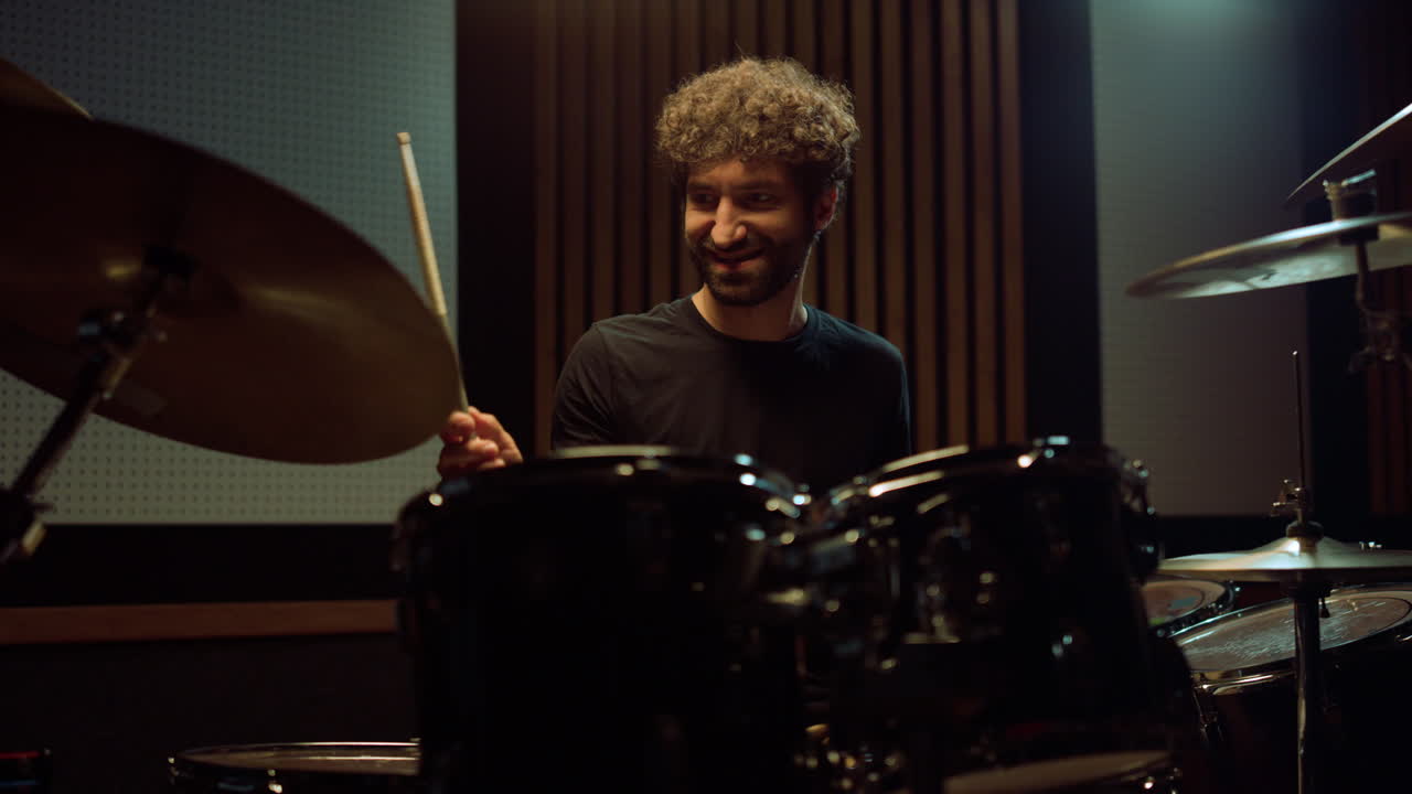 músico alegre tocando la batería en el interior. artista alegre divirtiéndose en la sala.