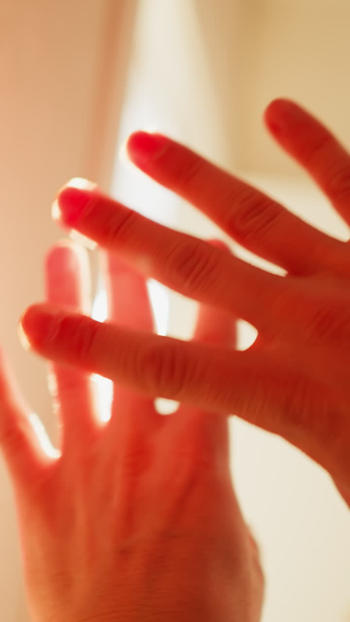 pov juego de manos a la luz del sol, los dedos crean patrones contra los rayos cegadores, la cámara de mano captura el brillo cálido