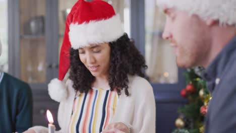 Dos-Amigos-Diversos,-Femeninos-Y-Masculinos,-Con-Gorros-De-Papá-Noel-Rezando-En-Navidad