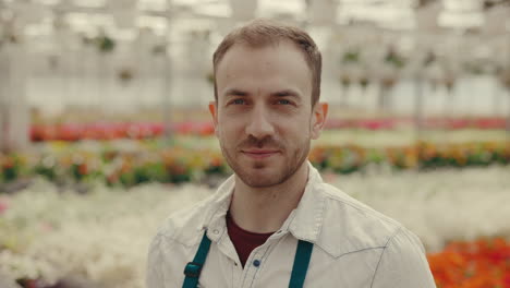 portrait of a smiling male gardener in a greenhouse