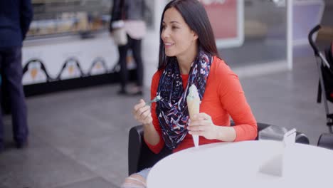 mujer comiendo un helado en un salón o cafetería