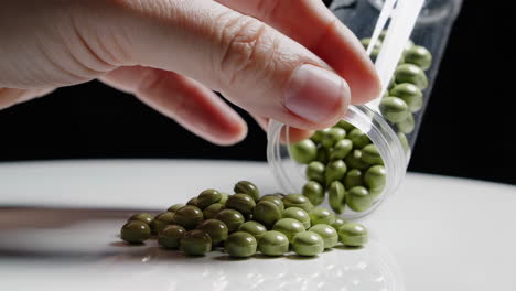 green pills pouring from container