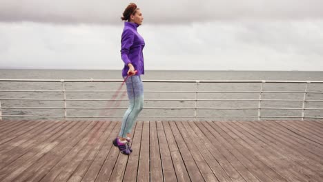 High-pace-video:-Young-woman-working-out-on-the-jump-rope.-Outdoor-sports.-Girl-jumping-on-a-skipping-rope-by-the-sea