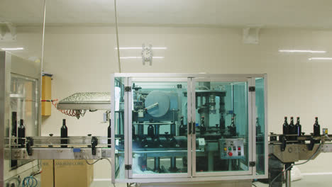 Slow-motion-wide-shot-of-wine-bottle-processing-machinery-inside-a-wine-factory-in-Burgos,-Spain